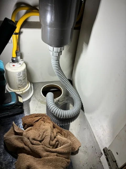 キッチン下の排水管・排水ホースを高圧洗浄し、通水を確認する様子(施工中)|さいたま市桜区