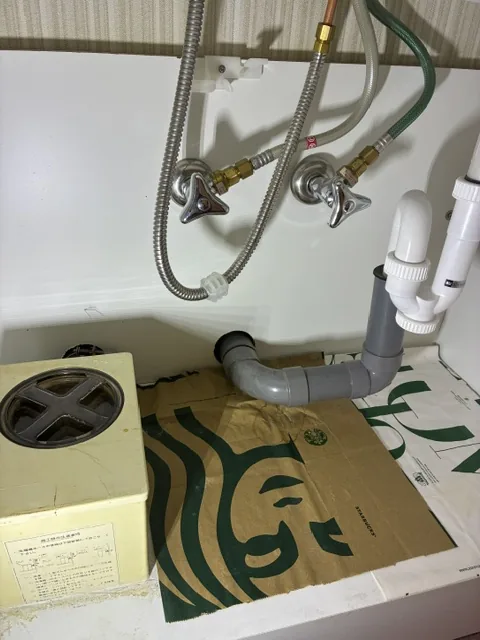 さいたま市桜区の洗面水栓交換｜施工前。洗面化粧台の扉内にある給水・給湯の止水栓と給水ホース、排水管