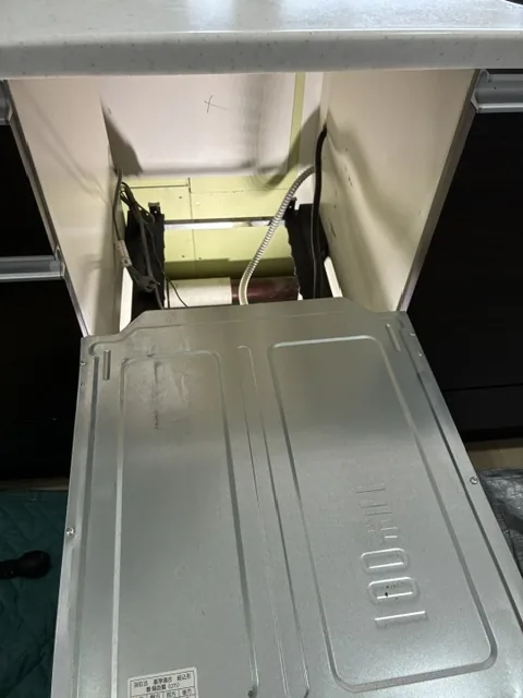 杉戸町のビルトイン食洗機交換|既設品の撤去作業。止水したうえで本体を引き出し、キッチンカウンターを傷つけないよう取り外す