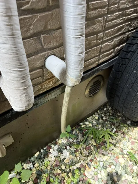 川口市の給湯器配管の漏水修繕|施工前。保温材が巻かれた配管が地面近くで曲がっている部分