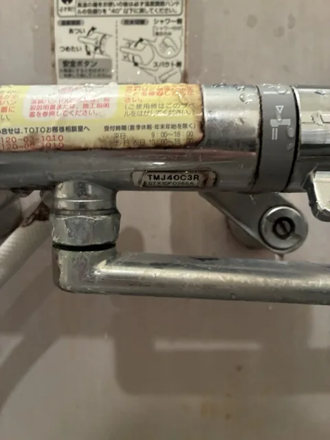 さいたま市桜区の浴室水栓交換｜施工前。既設水栓の本体に貼られた型番表示（TMJ40C3R）と、本体と配管の接続部分